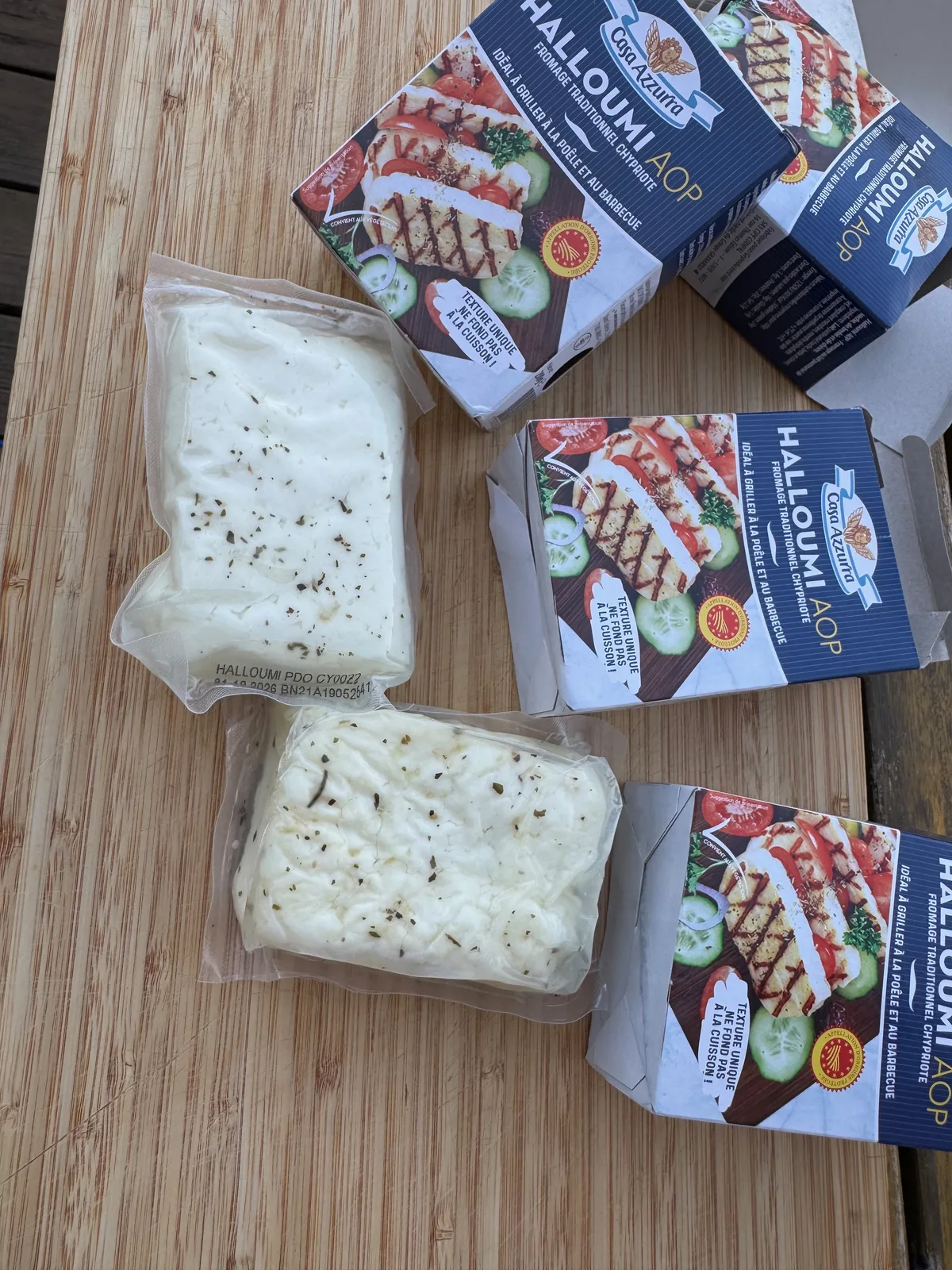Blocs de halloumi crus sous vide, parsemés de menthe séchée, sur une planche en bois
