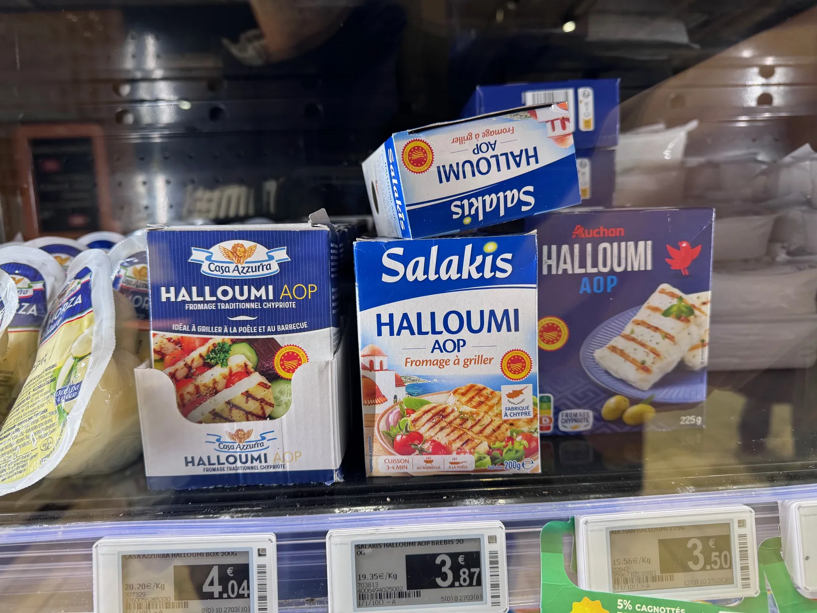 Rayon frais avec trois marques de halloumi AOP et leurs étiquettes de prix : Casa Azzurra, Salakis et Auchan